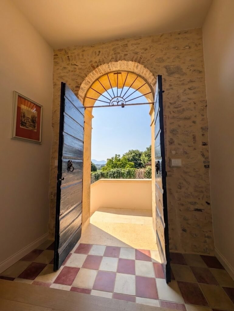 Arched door opening to a terrace and hill view over the Colli Berici
