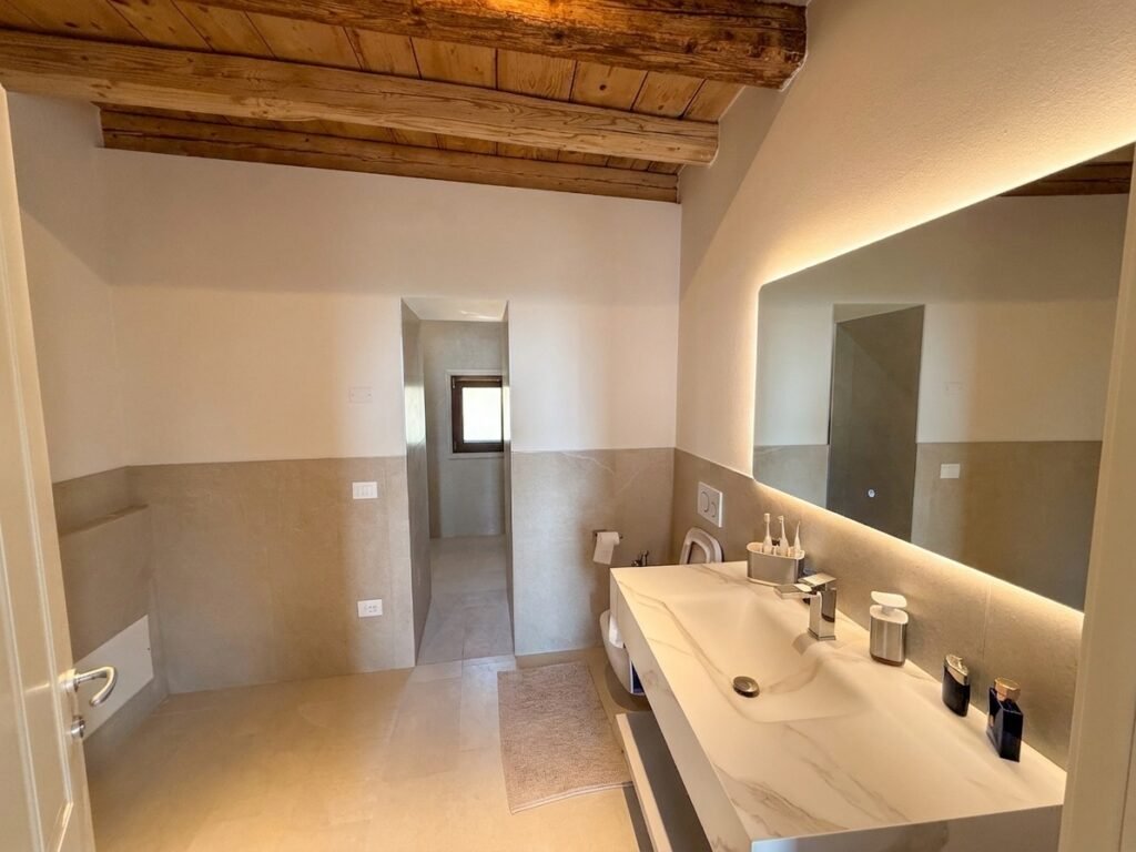 Ensuite bathroom with marble vanity and backlit mirror