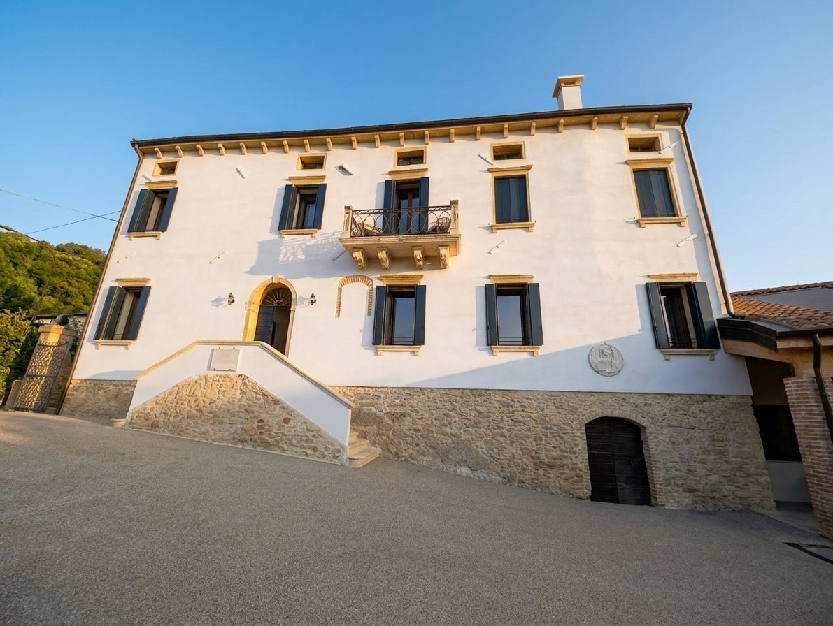 Restored Venetian facade of Tenuta Augusta with blue shutters and a stone base