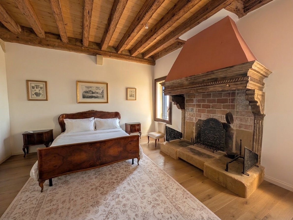 La Colombara bedroom with an original carved stone fireplace and beamed ceiling
